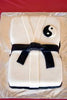 Rectangular white fondant cake styled as a martial arts gi with a tied black belt and yin-yang patch