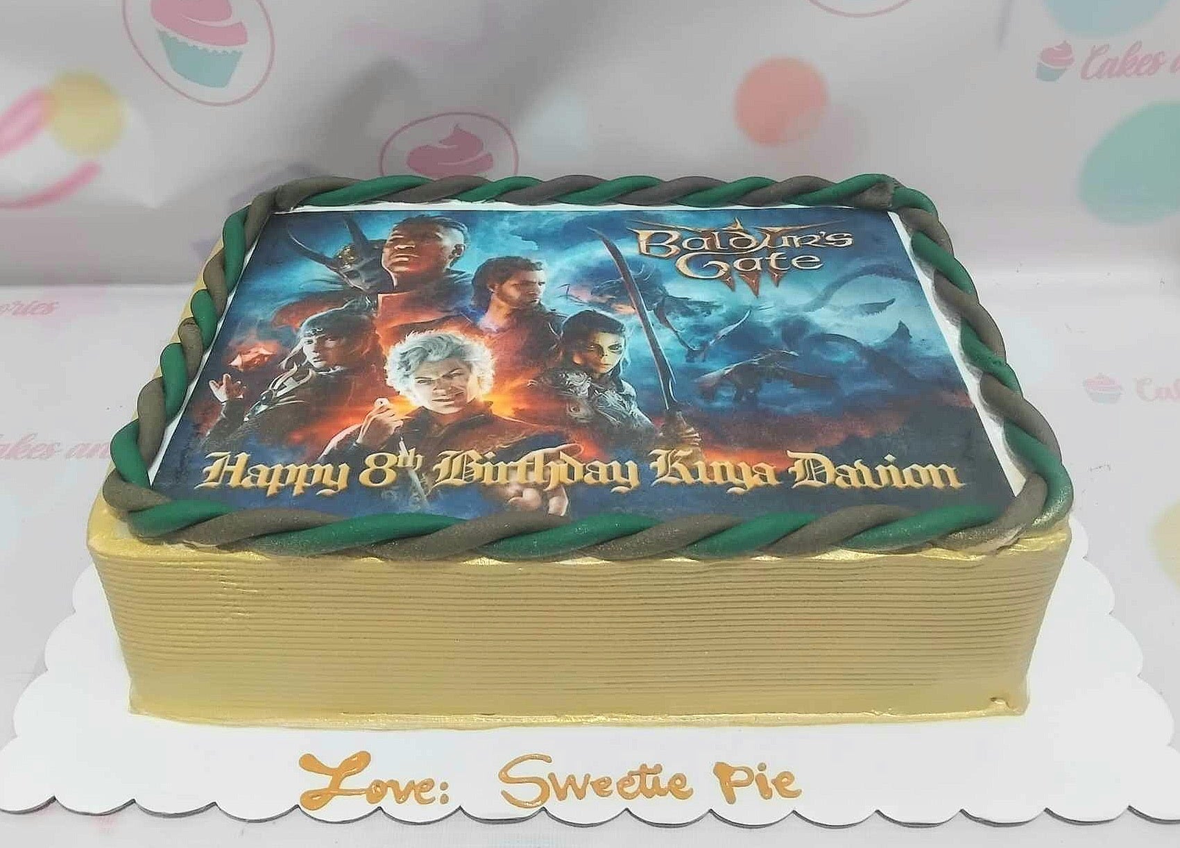 This vibrant rectangular Video Games Cake features a striking green and yellow design, showcasing an edible photo inspired by classic titles like Baldur's Gate, PUBG, and modern gaming consoles. Perfect for children's birthday celebrations, this customized cake captures the excitement of gaming culture.