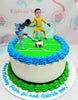 This soccer-themed cake features a white base with green icing, showcasing a detailed soccer field, a soccer ball, and football players including a goalie. Accented with blue details and printout toppers, it's the perfect centerpiece for any soccer celebration.