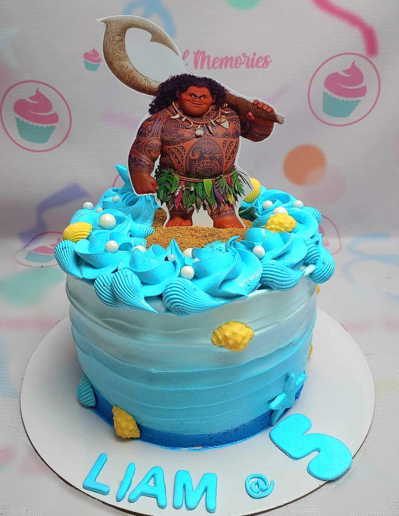 This Moana cake features a stunning blue ocean design with wave accents, perfect for any Disney fan. Adorned with printout toppers of Moana and Maui, this one-tier masterpiece captures the essence of adventure.