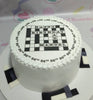 A stunning Crossword Puzzle Cake featuring a sleek black and white design with edible printed words that create an engaging puzzle effect. This one-tier, one-layer creation is perfect for puzzle enthusiasts and makes a memorable centerpiece for any occasion.