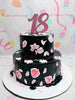 A stunning two-tiered floral cake adorned with black and pink roses and delicate petals, perfect for celebrating an 18th birthday or debut. This customized creation showcases elegant floral details that are ideal for mother’s celebrations.