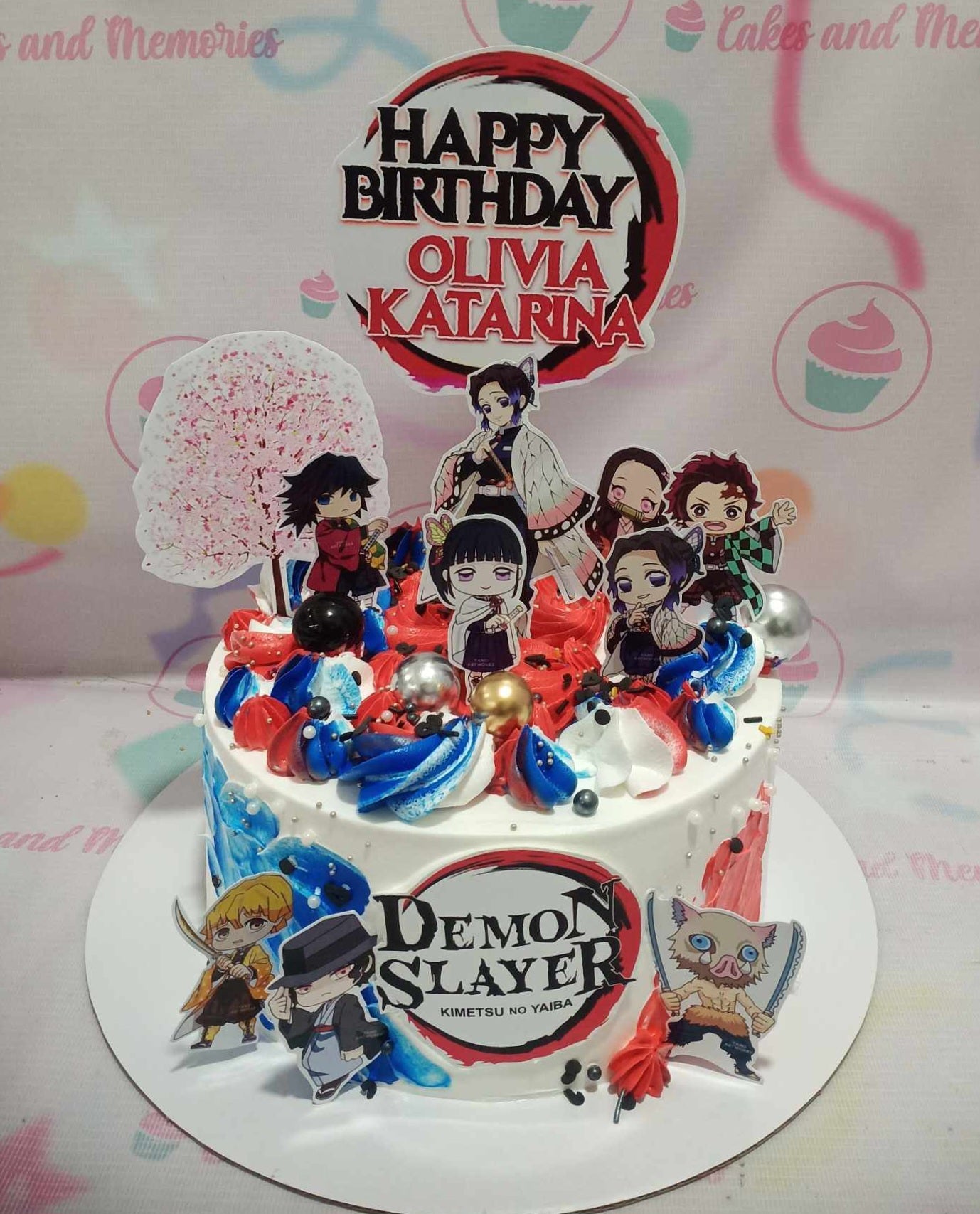 This stunning Demon Slayer cake features vibrant white, blue, and red colors adorned with cherry blossom designs, showcasing chibi printout toppers of Tanjiro Kamado, Nezuko Kamado, Giyu Tomioka, and other beloved characters. Ideal for any anime fan's birthday celebration, this 1-tier masterpiece captures the essence of Kimetsu no Yaiba in a delightful custom design.