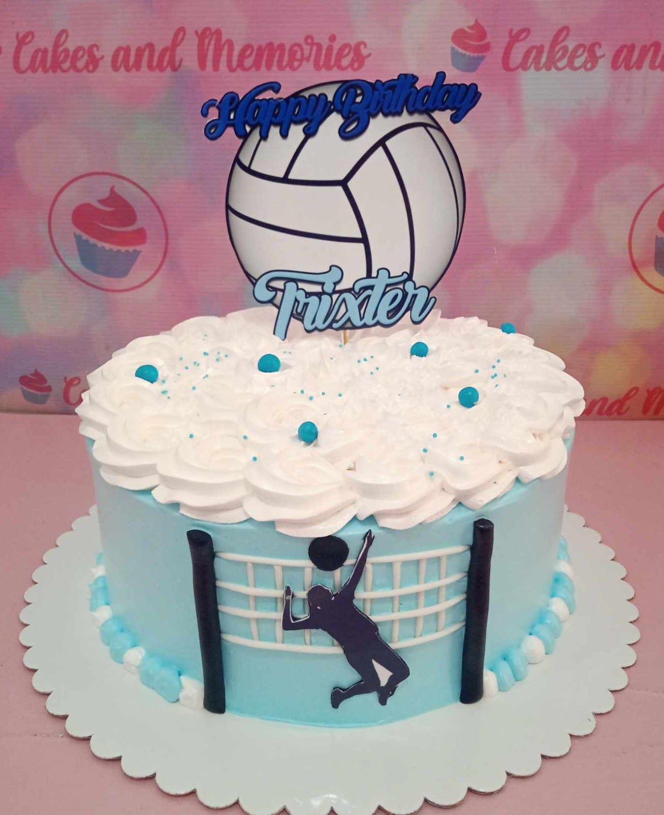 A unique light blue Volleyball Cake showcases a dynamic design featuring printout toppers of a hitter, libero, setter, and blocker, perfect for any sports-themed birthday celebration. This custom one-tier cake captures the essence of team spirit for kids and adults alike.