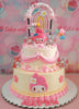 This adorable My Melody Cake features a two-tier design adorned in pastel pink and yellow tones, showcasing charming rainbow printout toppers of Sanrio characters. Perfectly crafted for any celebration, this cake brings cuteness to the forefront with its playful design.