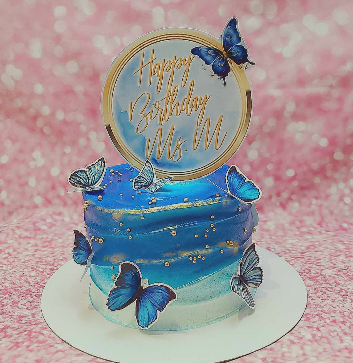 This stunning Butterflies Cake features blue ombre icing adorned with delicate butterflies and gold lining sprinkles, perfect for celebrating the birthday girl. Top with personalized printout toppers, it makes an ideal treat for tita, mama, or lola.