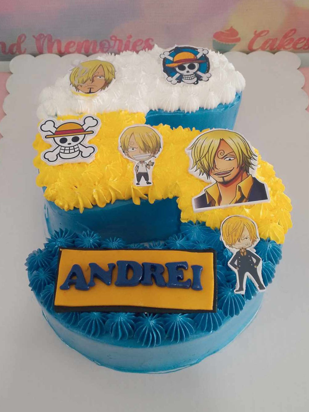 This vibrant rectangular One Piece cake features a playful design with shades of blue, white, and yellow, celebrating a 5th birthday for a young pirate fan. Adorned with Sanji and thematic elements, it's a perfect custom cake for kids who love anime adventures.