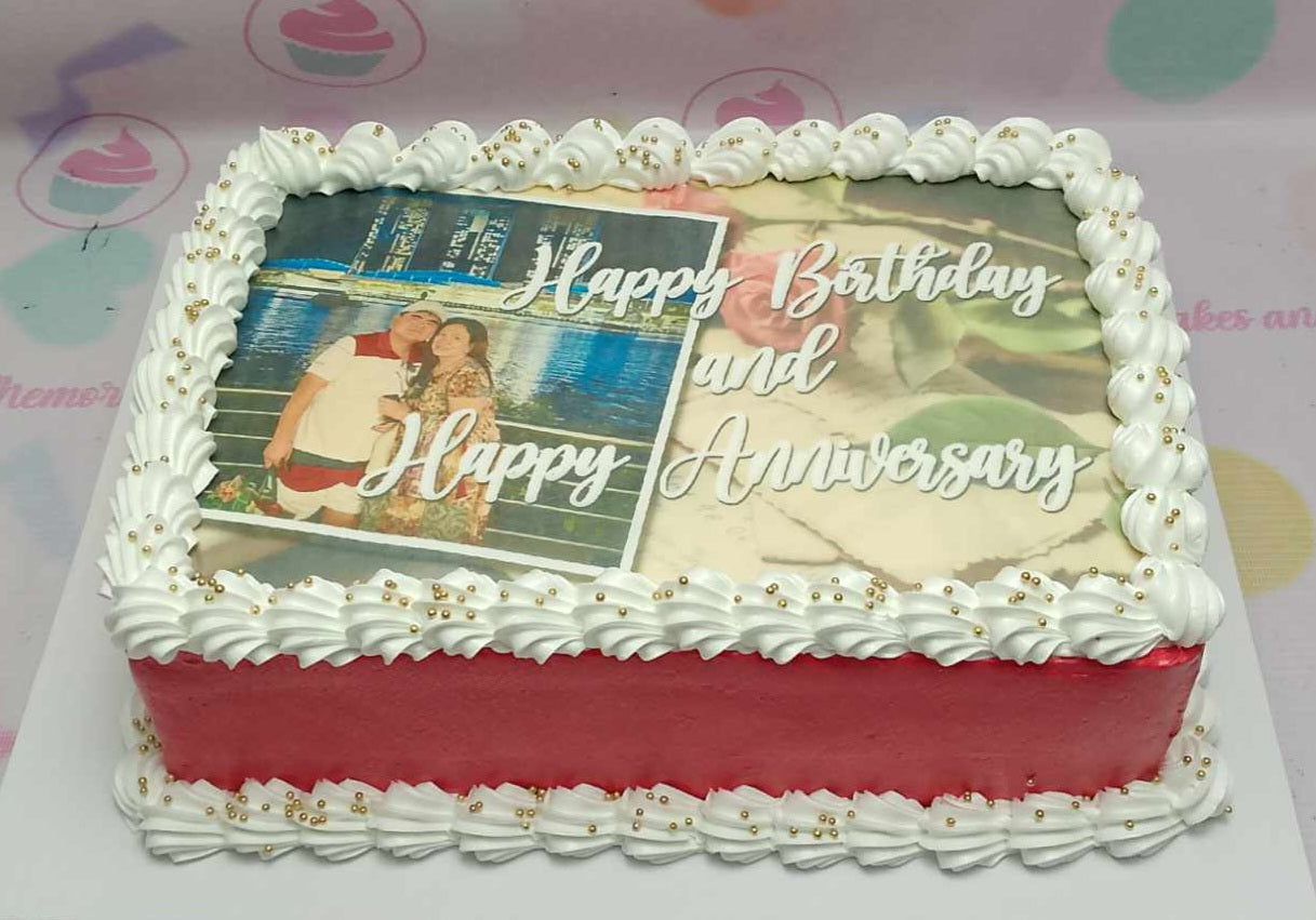 This elegant rectangular anniversary cake features a stunning design with rich red and white colors, adorned with delicate roses and small edible gold beads. It showcases a heartfelt edible photo, perfect for celebrating love on anniversaries, whether it's a wedding anniversary or a romantic monthsary.