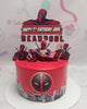 This Deadpool Cake features a striking red design with a cityscape backdrop, perfect for a 7th birthday celebration. Decorated with printout toppers of Marvel superheroes, it captures the essence of the iconic character from the MCU, making it ideal for young boys who love Deadpool and X-Men.