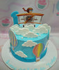 This vibrant Airplanes Cake features a stunning blue design adorned with whimsical white clouds and colorful hot air balloons. The cake is topped with eye-catching printout toppers showcasing planes and pilots, perfect for aviation enthusiasts.