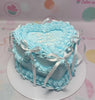 This vintage cake features a light blue design adorned with delicate hearts and elegant bows, perfect for a woman's 30th birthday celebration. The cake is topped with charming printout toppers, showcasing a stylish ribbon that complements its one-tier structure.