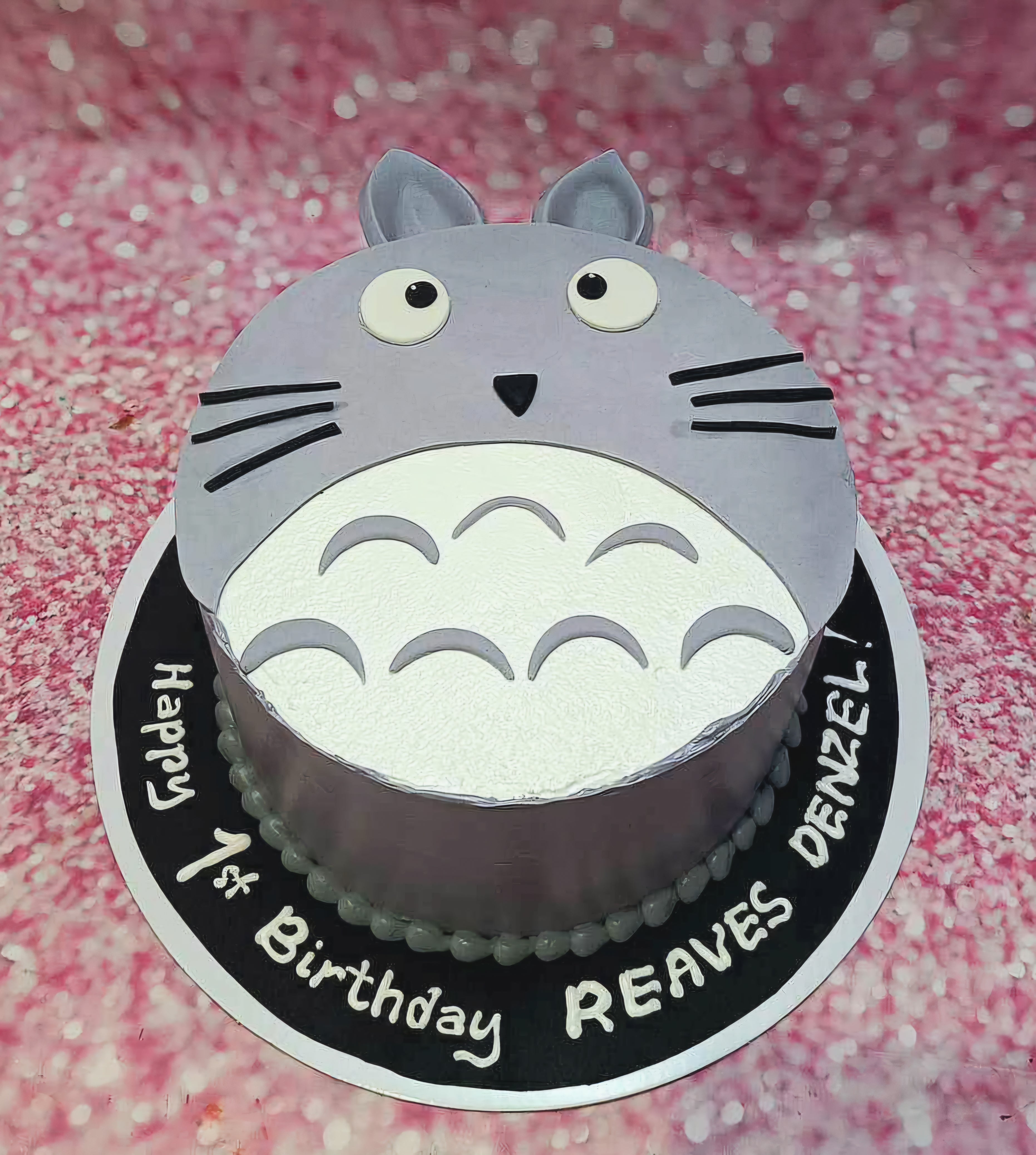 A charming Totoro cake featuring soft gray icing and adorable cute whiskers, perfect for a 1st birthday celebration for Denzel Reaves. Crafted in honor of the beloved Ghibli studio anime, this one-tier design captures the essence of my neighbor Totoro.