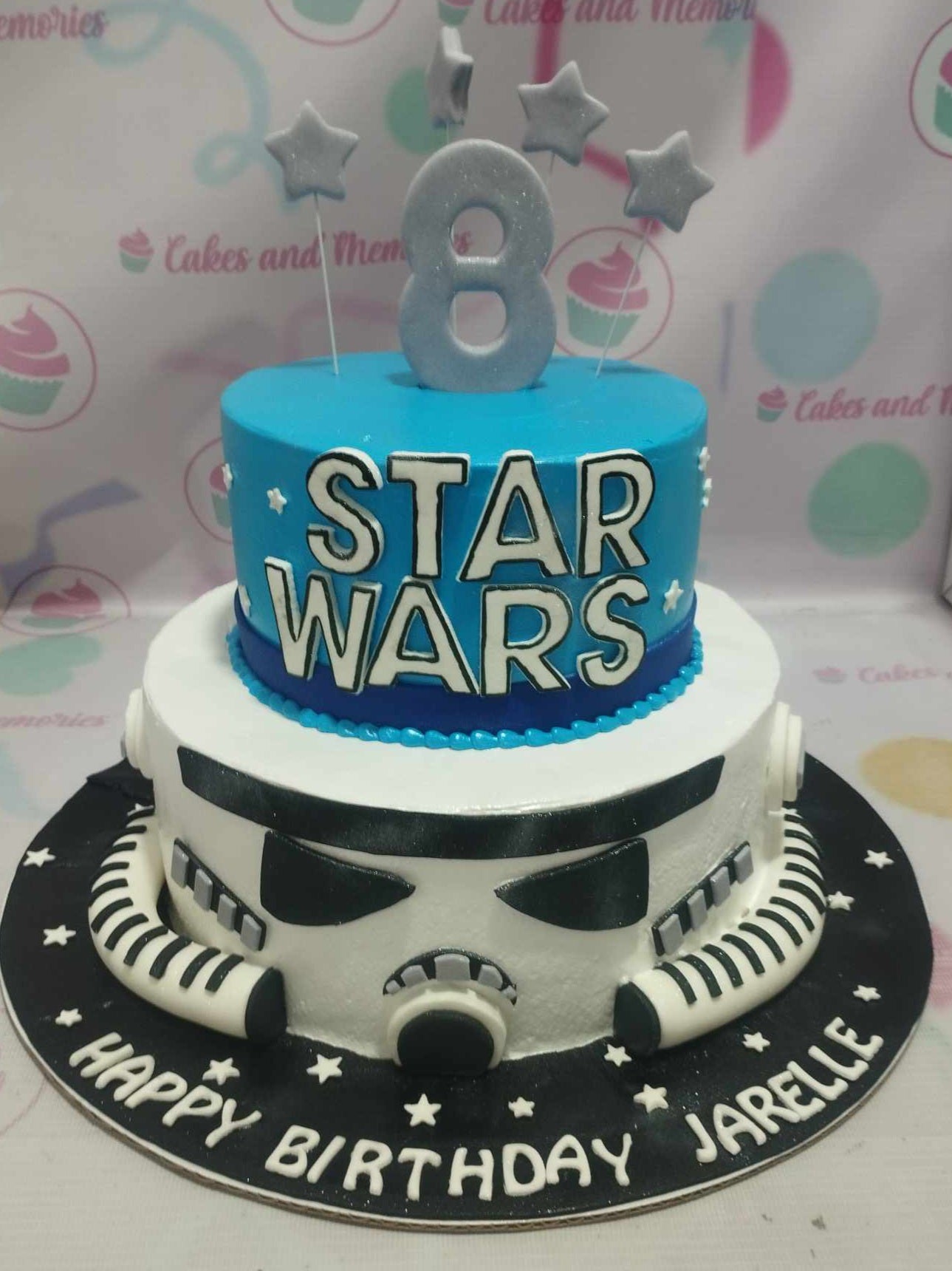 This stunning 2-tier Star Wars cake features a vibrant blue and white design, perfect for an 8th birthday celebration, complete with a detailed Stormtrooper helmet and Jedi accents. Custom decorated to truly embody the excitement of the galaxy far, far away, it’s a memorable centerpiece for any birthday party.