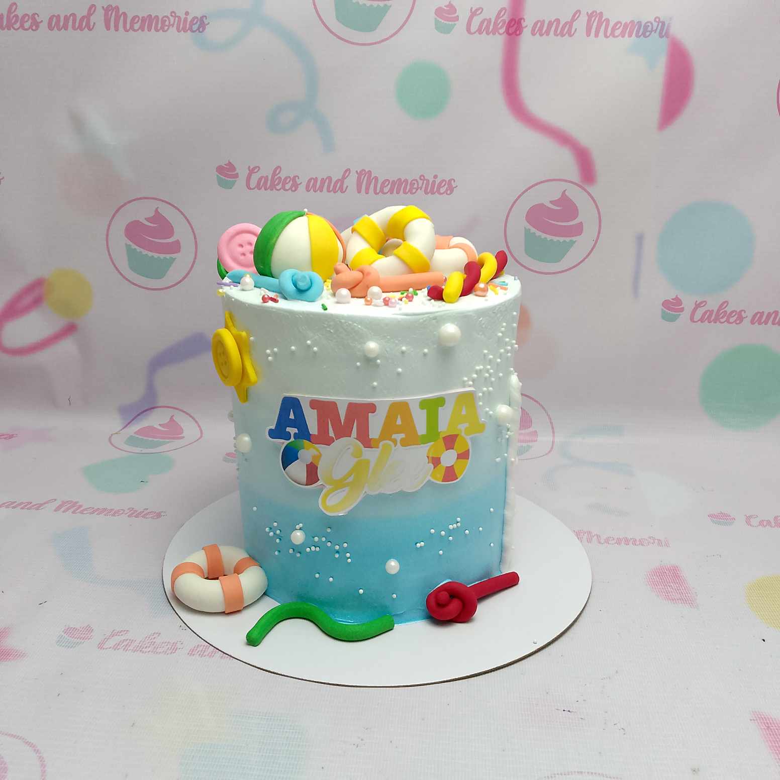 This stunning beach-themed cake features a vibrant blue design, perfect for a summer swimming party, complete with playful floaties, a beach ball, and a snorkel accent. Standing tall as a delightful 1-tier creation, it captures the essence of fun in the sun for any birthday celebration.