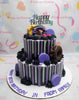 This stunning two-tier drip cake features a sleek black and purple design, adorned with elegantly placed macarons and colorful donuts. The vibrant purple drip cascading down creates a visually striking centerpiece perfect for an 18th birthday celebration.