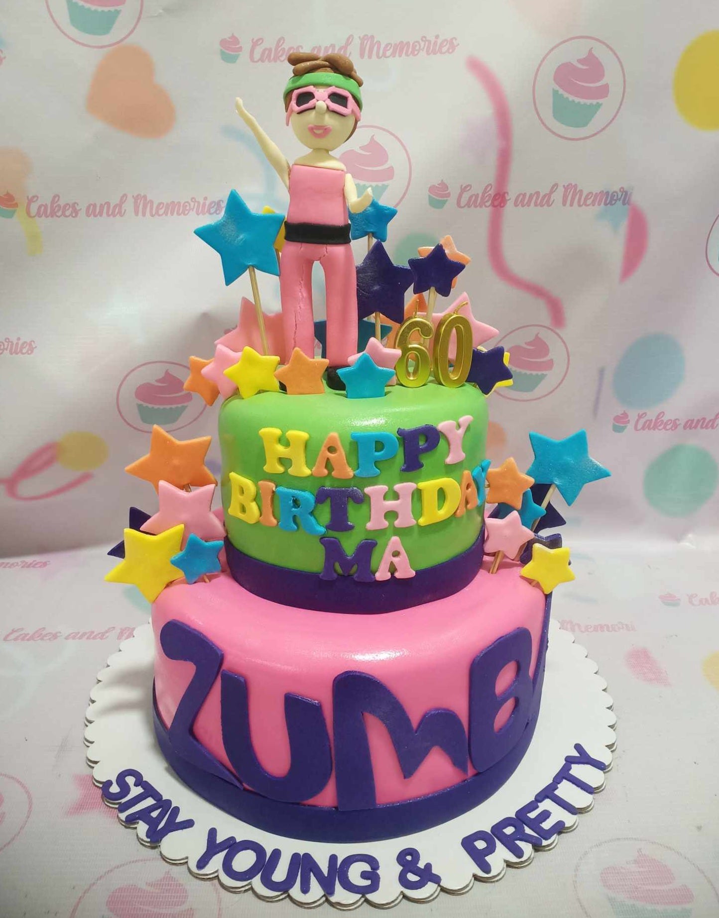 This vibrant 2-tier Zumba cake features a lively green and pink design adorned with an edible topper celebrating a 60th birthday for a dance-loving grandmother. Decorated with stars and fitness motifs, it perfectly embodies the spirit of aerobics and exercise.