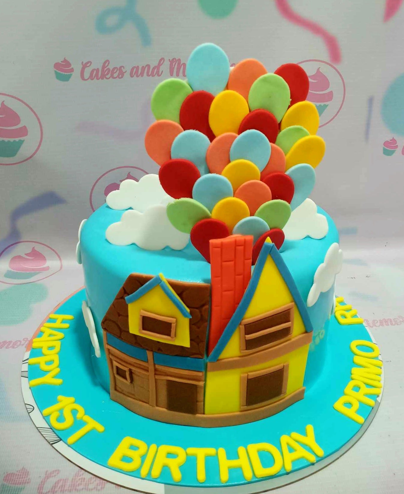 This vibrant Balloon Cake features a whimsical design inspired by Pixar's adventure theme, showcasing a colorful blue and yellow palette with playful fondant balloons soaring into a cloudy sky. Celebrating Carl and Russell, this 1-tier creation is perfect for any adventurous birthday celebration.