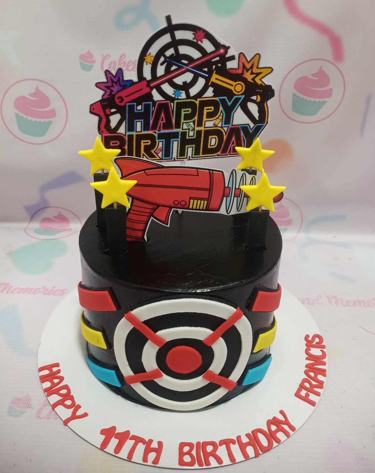 This custom Nerf Cake features a sleek black design adorned with vibrant target and blaster weapon printout toppers, perfect for any laser tag-themed birthday celebration. With its single tier and playful toy gun accents, it captures the excitement of kids' favorite toys.