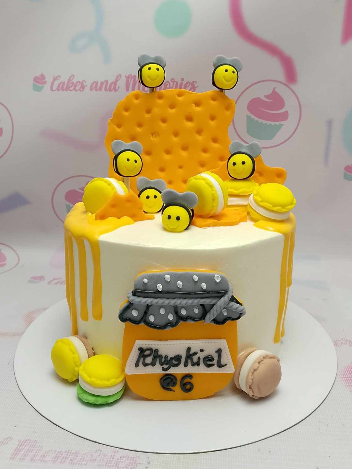 This vibrant Bugs Cake features a stunning honeycomb design adorned with playful bees and delightful macarons. The whimsical yellow drip and a charming honey jar make it the perfect centerpiece for a 6th birthday celebration.