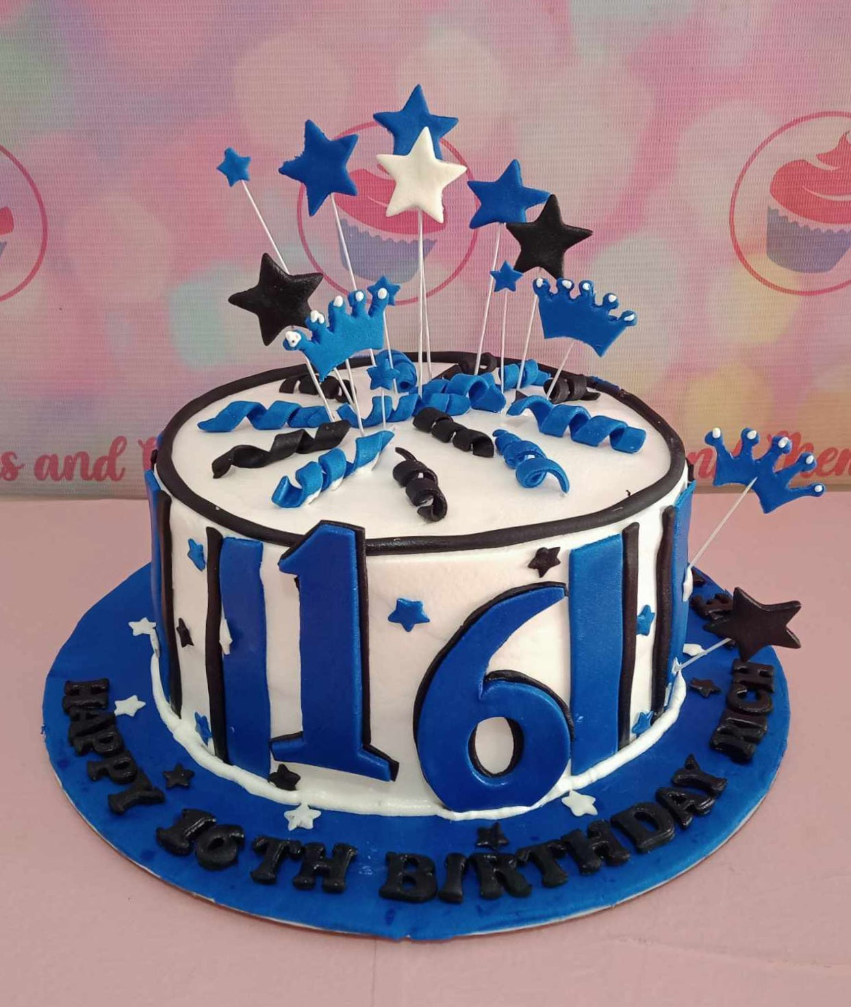 This stunning blue and white Ribbon Cake features delicate edible little crown toppers and whimsical edible stars, perfect for celebrating a teenager's sweet sixteen. The one-layer, one-tier design makes it an ideal customized gift for a memorable 16th birthday celebration.