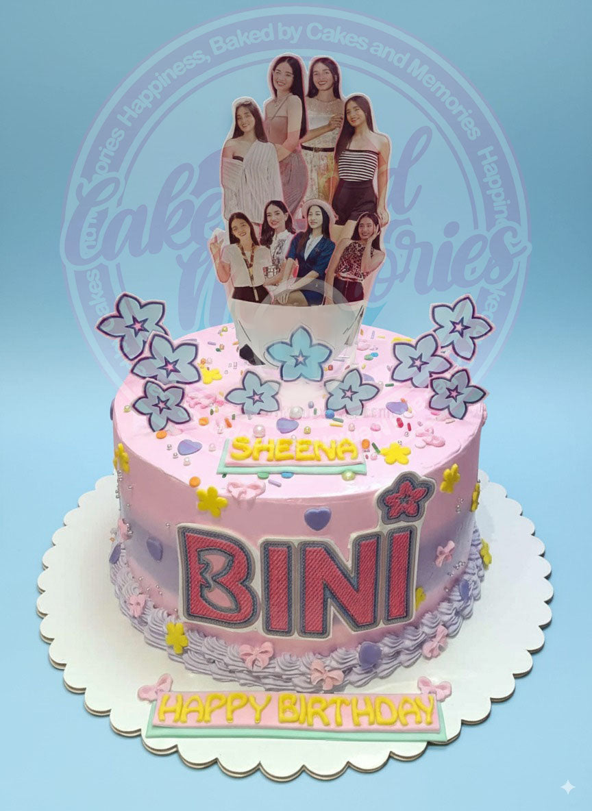 One-tier BINI birthday cake with ombre pink and purple buttercream, edible BINI member toppers, 'SHEENA' and 'HAPPY BIRTHDAY' plaques.