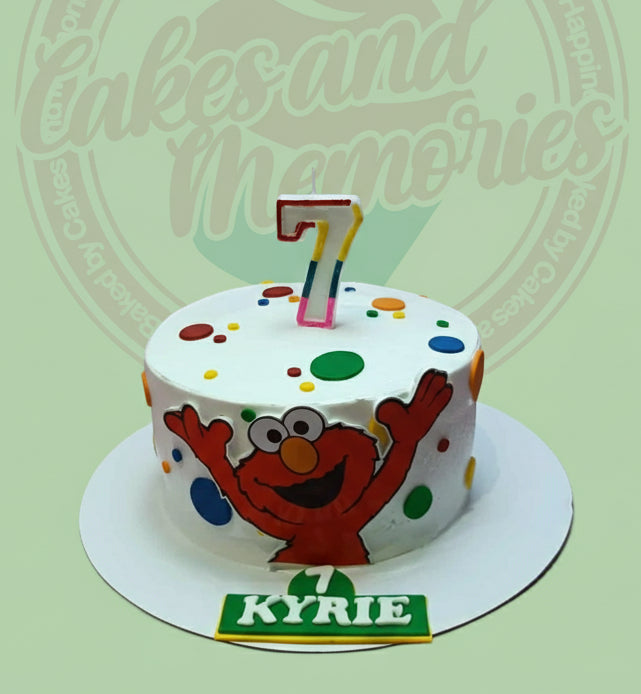 Round Elmo 7th birthday cake with colorful polka dots, a number 7 candle, and 'KYRIE' plaque on white icing.