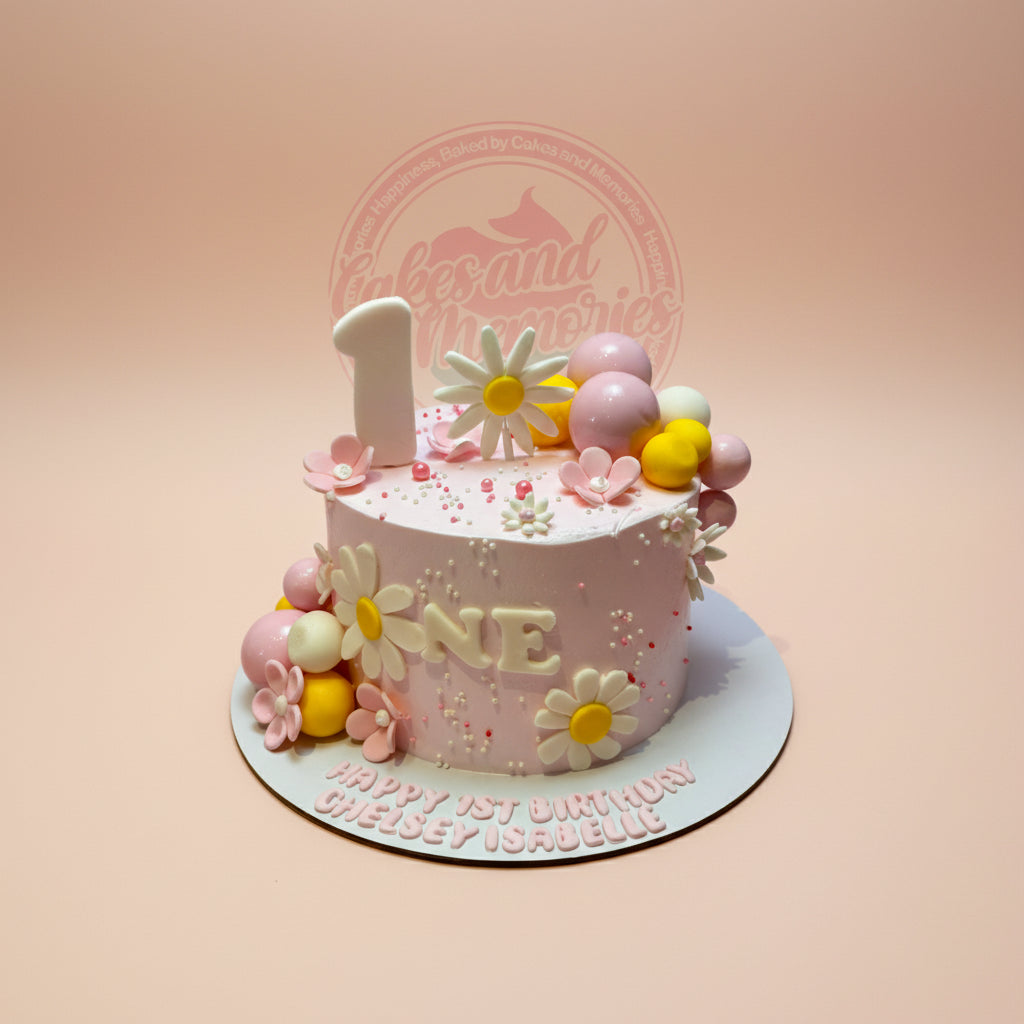 One-tier first birthday cake for Chelsey Isabelle with pink buttercream, daisy flowers, pink/yellow/white spheres, and '1' topper.