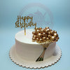 One-tier white birthday cake with gold champagne bubbles, edible bottle print, and 'Happy Birthday' topper.