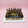 Rectangular chocolate drip birthday cake for Shella's 30th, topped with chocolates, bars, and gold sprinkles.