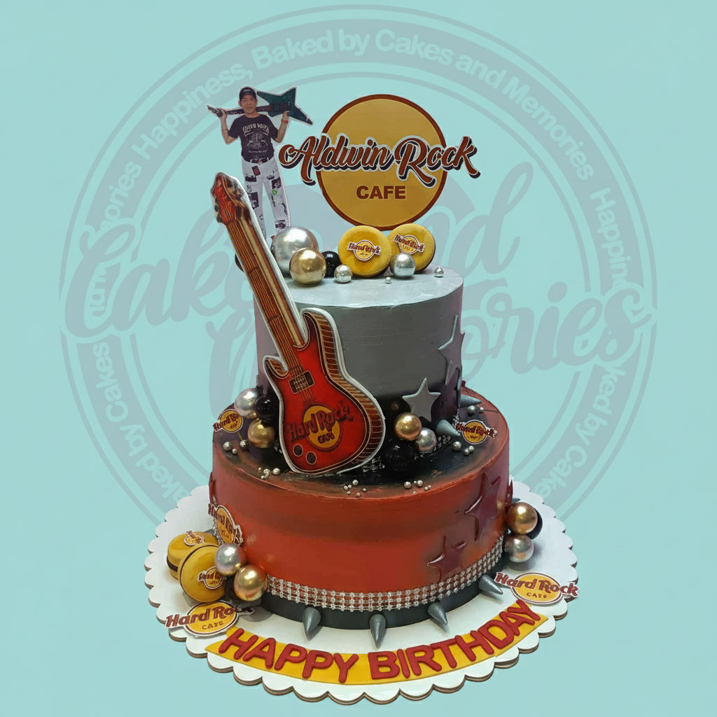 Two-tier Hard Rock Cafe themed birthday cake with a red electric guitar, 'Aldwin Rock Cafe' topper, and 'Happy Birthday' text.