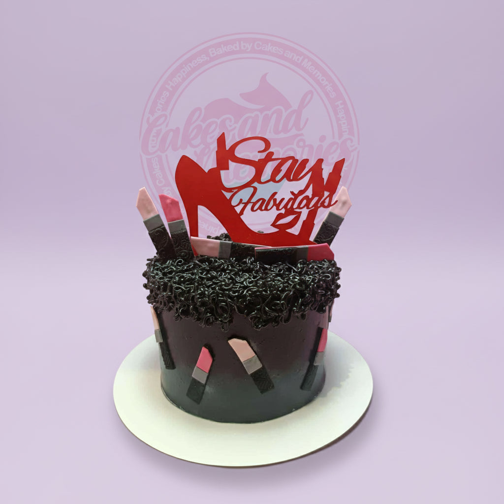 One-tier fashion-themed birthday cake with dark gradient frosting, lipstick decorations, and a red 'Stay Fabulous' topper.