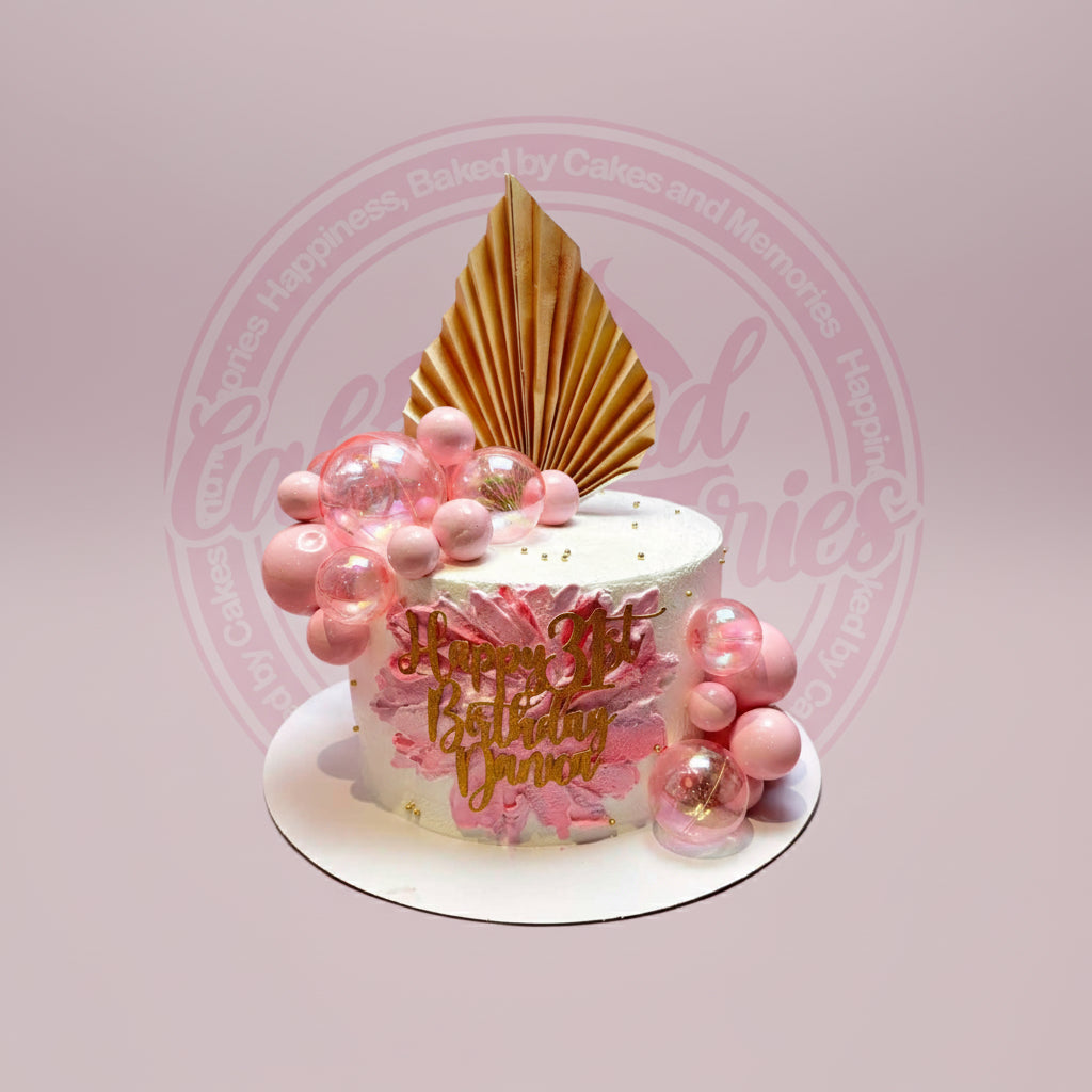 One-tier rose gold birthday cake with pink bubbles, gold fan, and "Happy 31st Birthday Dana" topper on white buttercream.