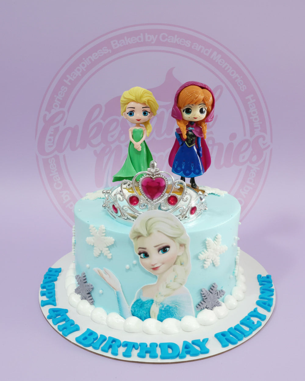 One-tier Frozen birthday cake with Elsa edible print, Anna and Elsa toppers, crown, and snowflakes for Riley Anne's 4th birthday, light blue.