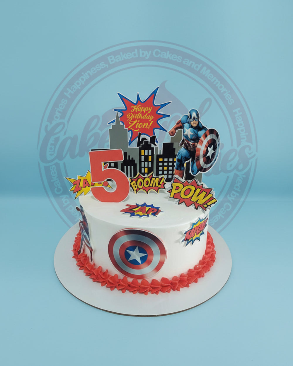 One-tier Captain America birthday cake for Zion's 5th birthday, with cityscape, comic bubbles, and red & blue accents.