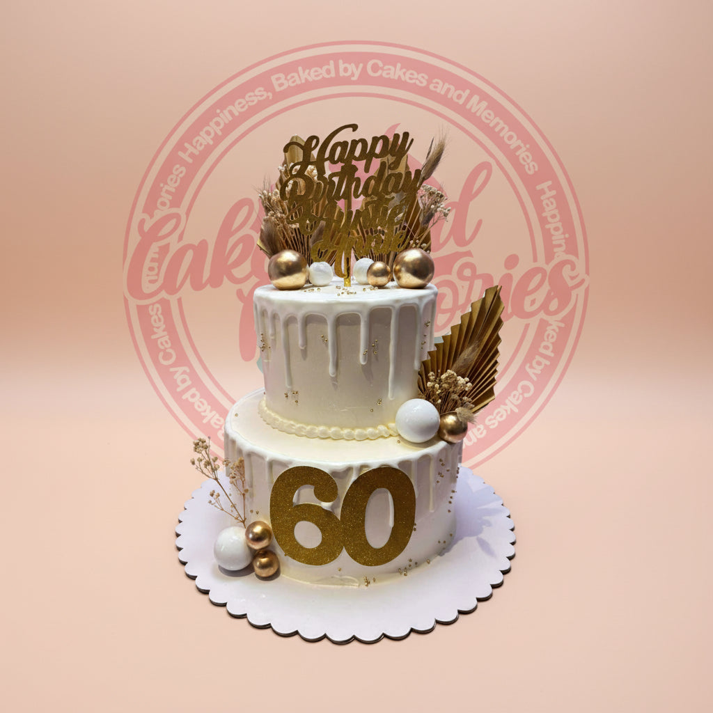 Two-tier 60th birthday cake with elegant white and gold drip design, "Happy Birthday" topper, and large "60" age.