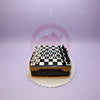 One-tier chess theme birthday cake featuring a black and white chessboard, edible chess pieces, and 'HAPPY BIRTHDAY ILYSM' in white.