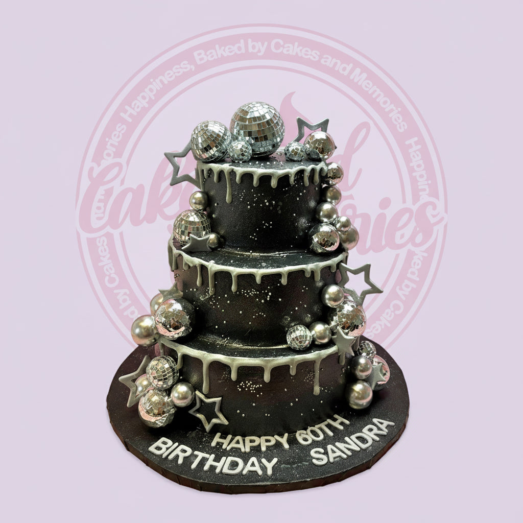 Three-tier black and silver disco birthday cake with disco balls, stars, drip icing, and 'Happy 60th Birthday Sandra'.