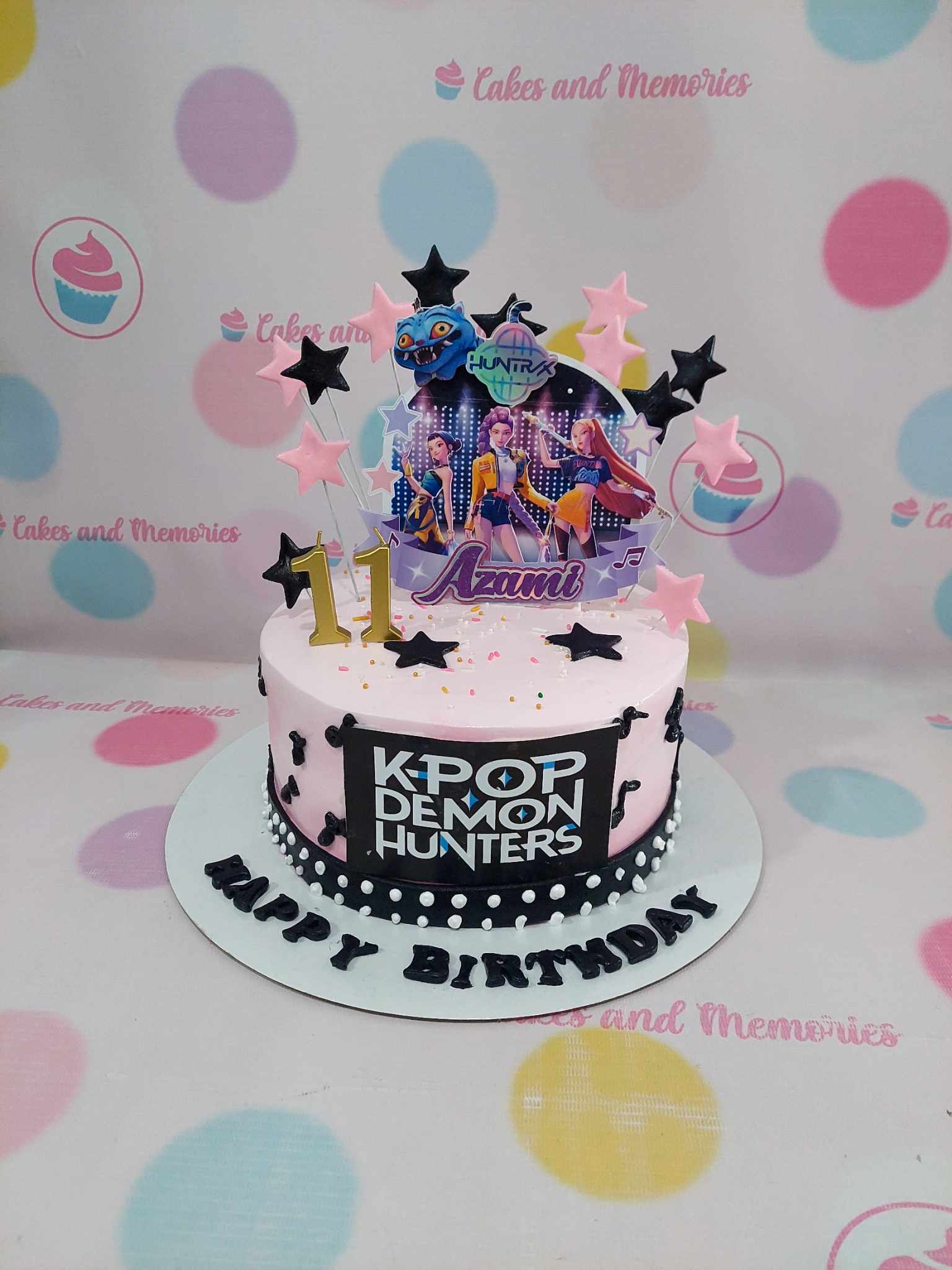 K-Pop Demon Hunters birthday cake for Azumi's 11th, pink & black buttercream, edible print, star toppers.