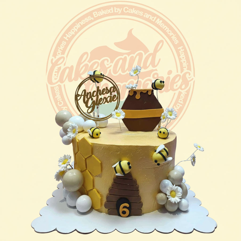 One-tier yellow buttercream bee-themed birthday cake for Anchesa Glexie, age 6, with honeycomb, beehive, honey pot, bees, and daisies.
