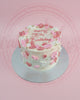 1-tier 18th birthday cake with pink and white buttercream flowers, gold pearls, and 'Happy 18th Birthday' text