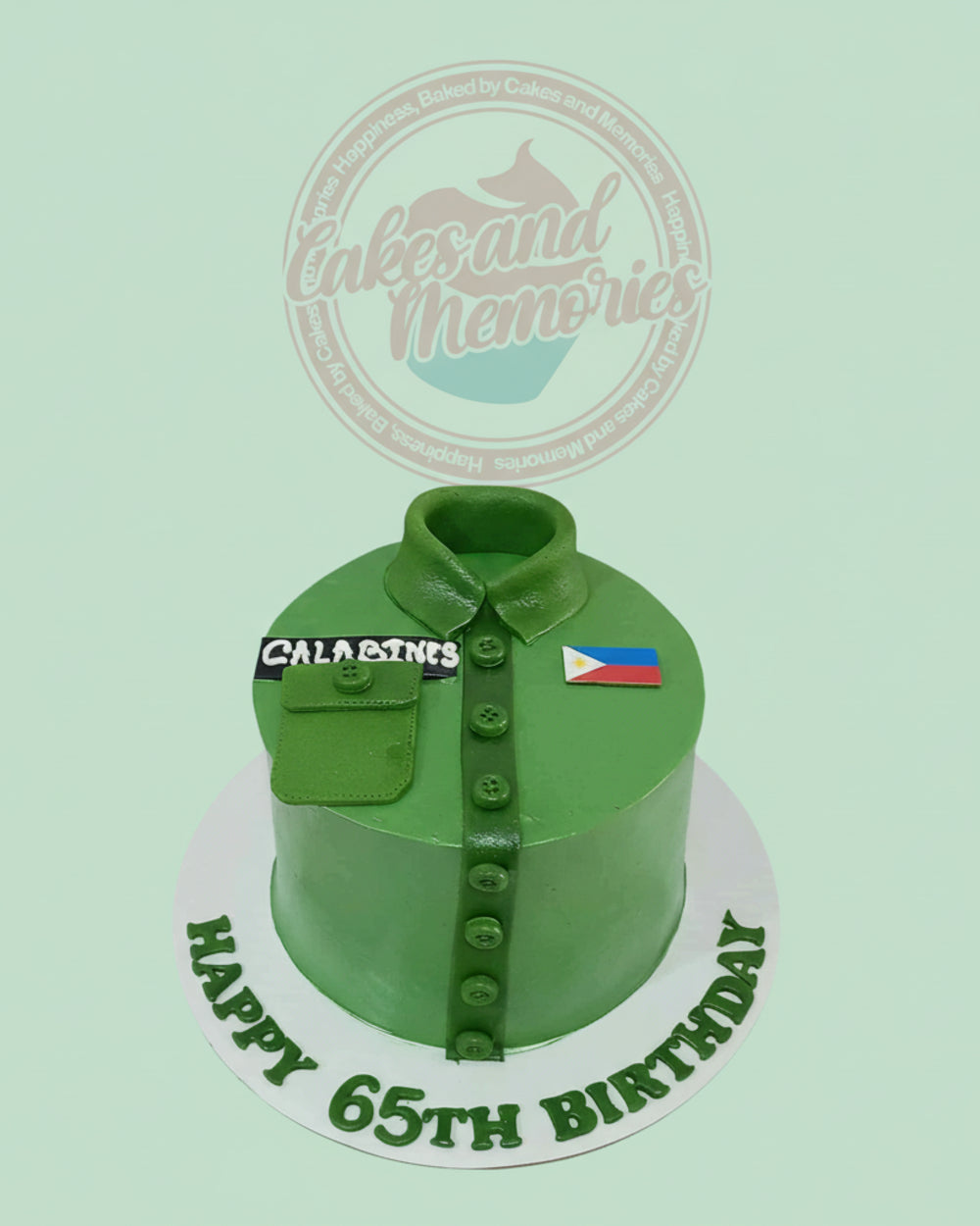 Green military uniform shirt cake for a 65th birthday, personalized with 'CALABINES' name tag and a Philippine flag. One-tier custom cake.