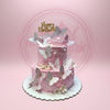 Two-tier pink butterfly birthday cake with white pearls, edible flowers, and a gold 'Happy Birthday' topper for Keziah Aishi.