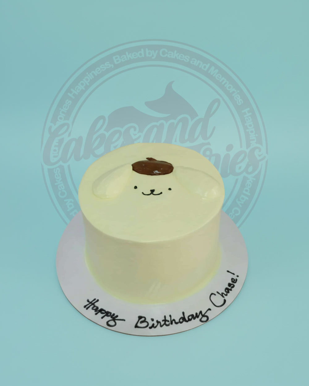 One-tier Pompompurin birthday cake with smooth yellow buttercream, hand-piped character details, and "Happy Birthday Chase!" text.