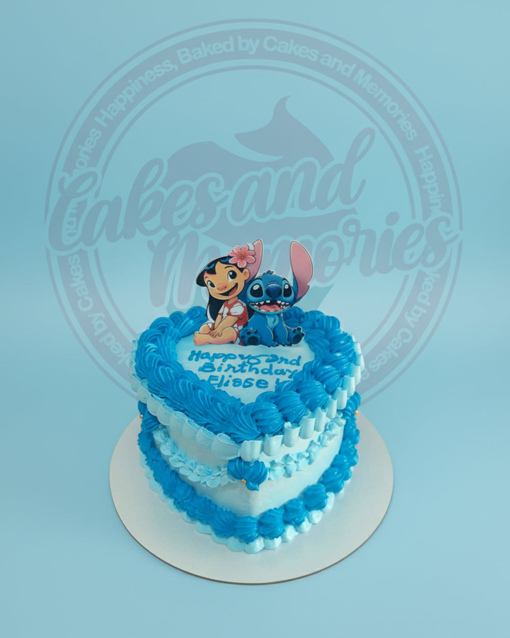 Heart-shaped Lilo & Stitch birthday cake with edible print of Lilo and Stitch, blue & white buttercream icing for 'Happy 3rd Birthday Elisse'.