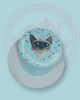 One-tier blue birthday cake with an edible print of a cute cat, colorful sprinkles, and 'Happy 2nd Birthday Hoshi!' text.