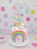 One-tier Unicorn Rainbow Birthday Cake with pastel rainbow, white unicorn, clouds, gold stars. Personalized with 'ALI' & '7'. Pink icing.
