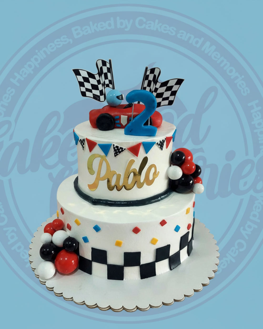 Two-tier racing birthday cake for Pablo with red race car, blue '2' topper, checkered flags, and colorful accents.