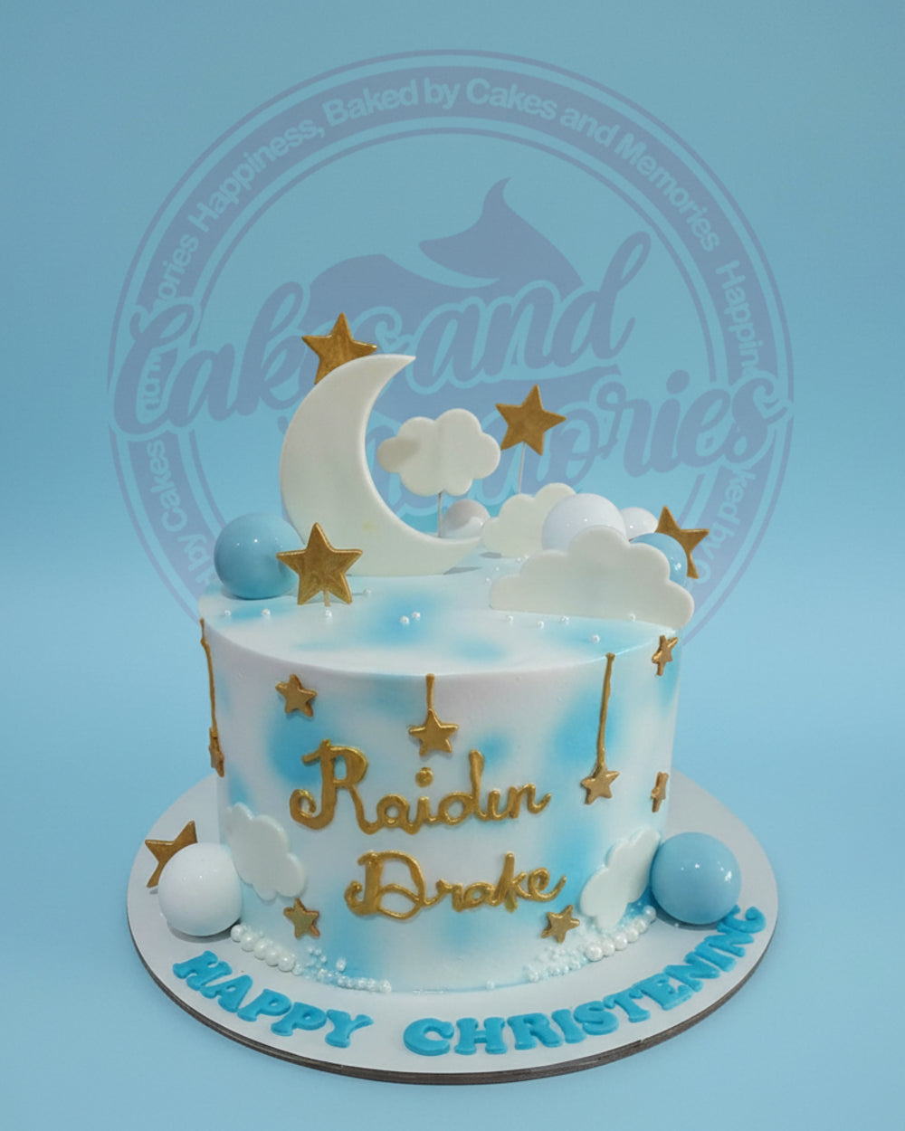 One-tier christening cake with blue and white airbrushed clouds, gold moon and stars, personalized for Raidun Drake.