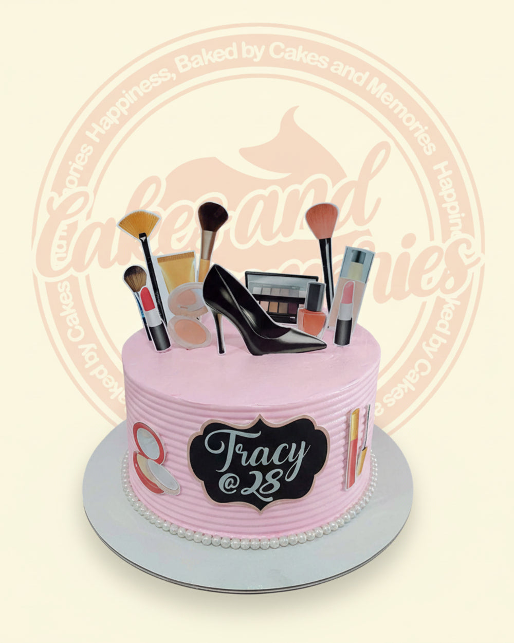 One-tier pink buttercream cake with makeup and black high-heel shoe toppers, edible pearls, and 'Tracy @ 28' plaque. Custom fashion birthday cake.
