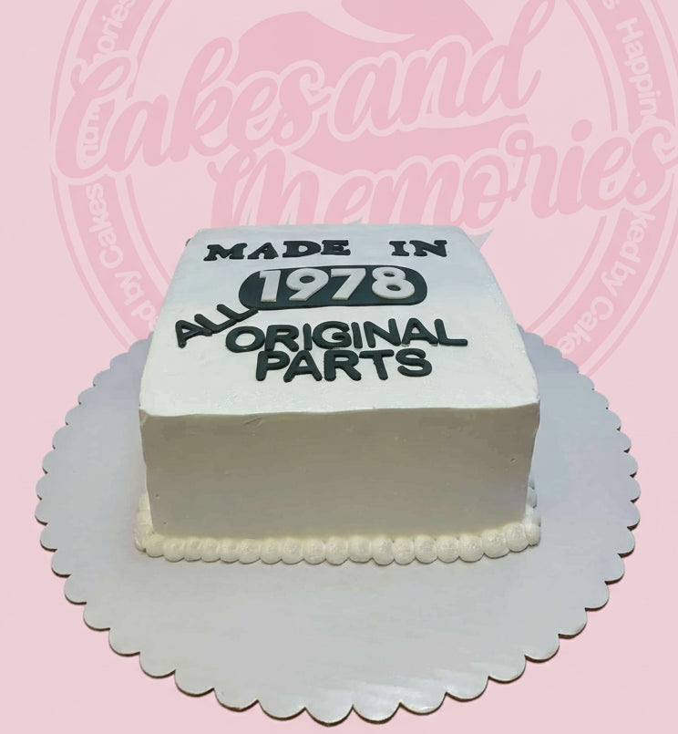 Custom birthday cake with 'Made in 1978 All Original Parts' text in black on white square buttercream cake.